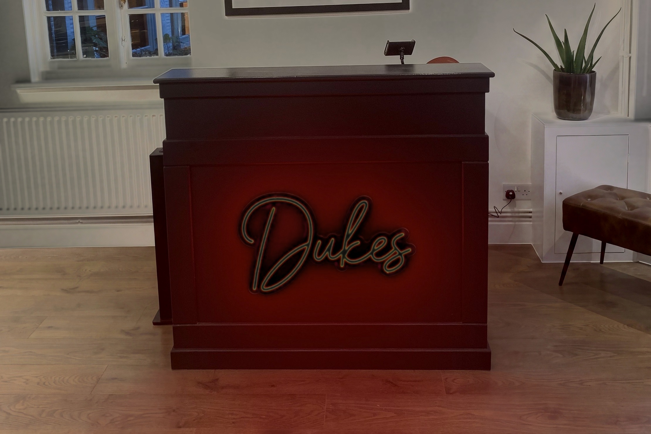 The reception desk at Dukes Barbershop, Old Harlow, with its red neon sign